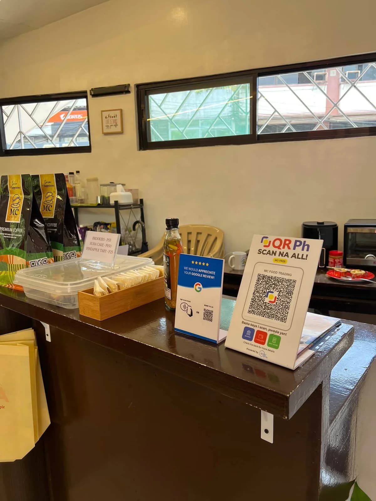 A blue Goreview stand beside a payment QR sign on a coffee shop counter.